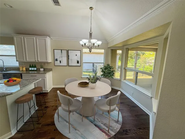 a dining room with furniture a chandelier and wooden floor