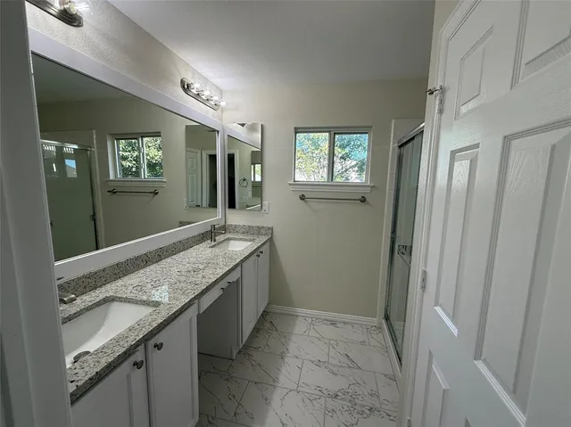 a bathroom with a granite countertop sink and a mirror