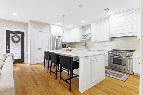 a kitchen with a table chairs refrigerator and cabinets