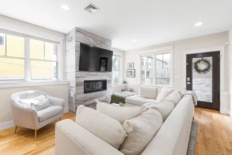 a living room with furniture a flat screen tv and a fireplace