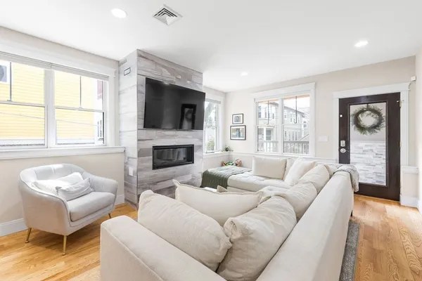 a living room with furniture a flat screen tv and a fireplace