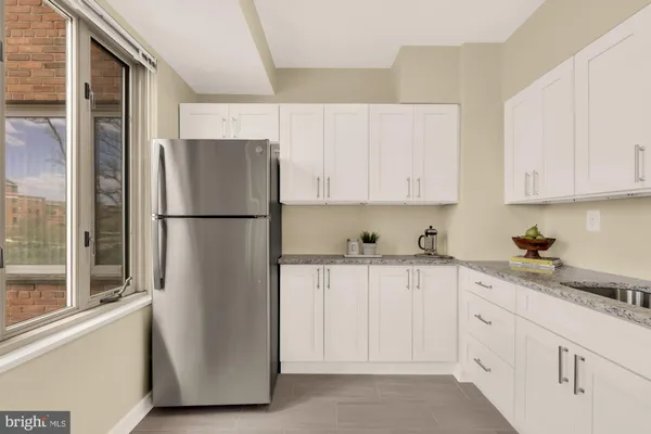 a kitchen with stainless steel appliances white cabinets and a refrigerator