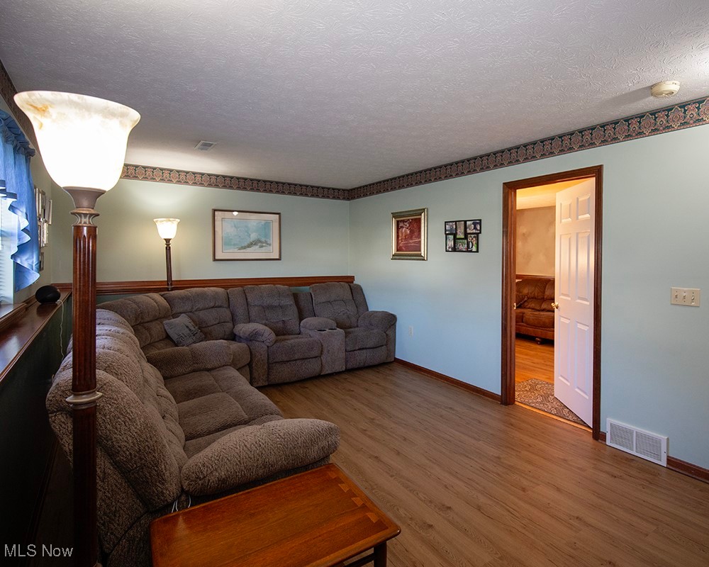 1614 South Abbe Road Elyria, OH 44035 - Photo 23 of 35 Living area with visible vents, baseboards, a textured ceiling, and wood finished floors