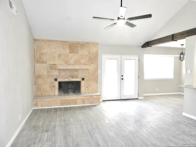 a view of empty room with wooden floor and fireplace
