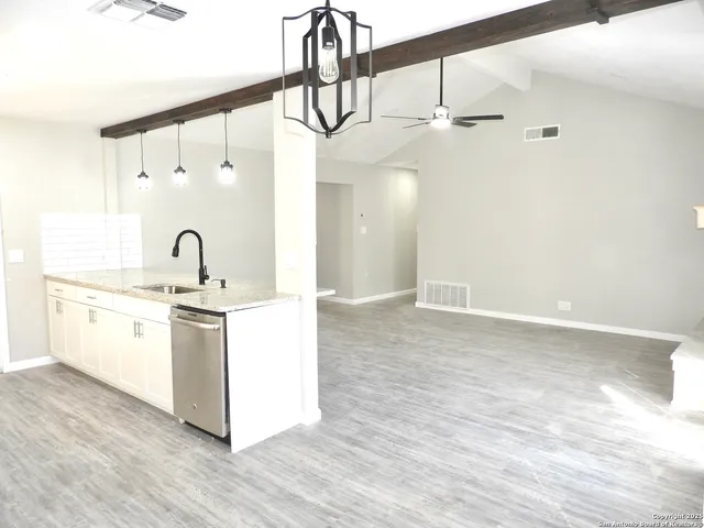 a kitchen with kitchen island a sink and wooden floor