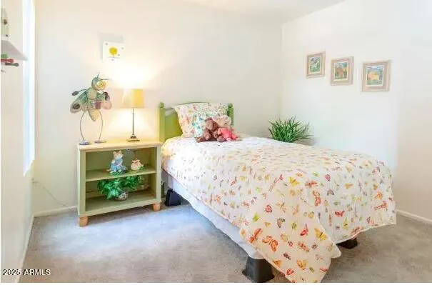 a bedroom with a bed and painting on the wall