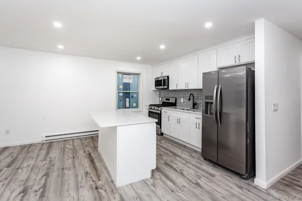 a kitchen with a refrigerator a sink and cabinets