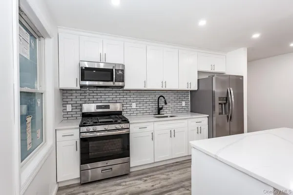 a kitchen with cabinets stainless steel appliances and sink