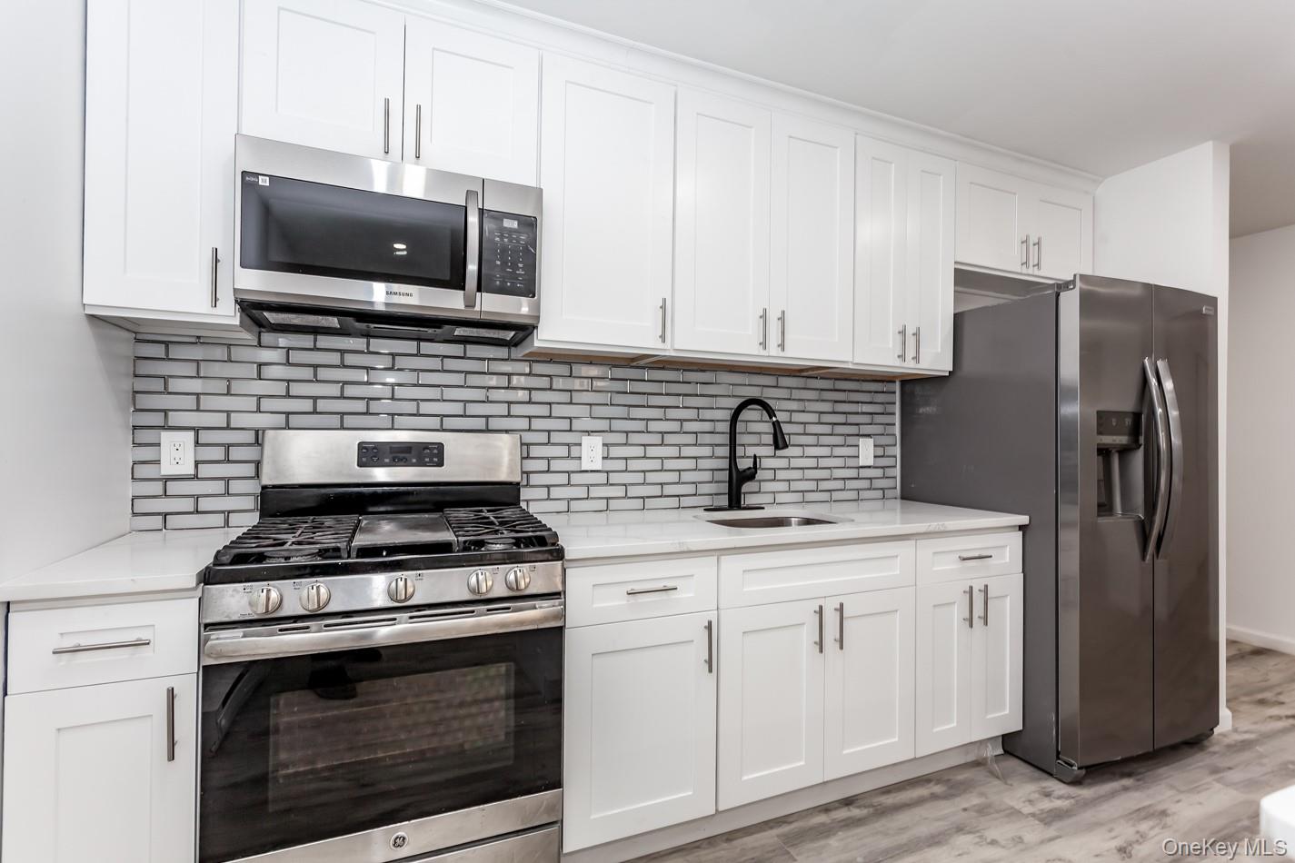 300 Highland Avenue, Unit 5 Peekskill, NY 10566 - Photo 15 of 17 a kitchen with stainless steel appliances granite countertop a stove a refrigerator and a microwave