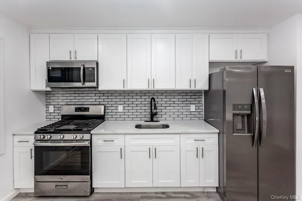 a kitchen with cabinets stainless steel appliances and a counter space