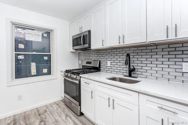 a kitchen with stainless steel appliances granite countertop a sink stove and microwave