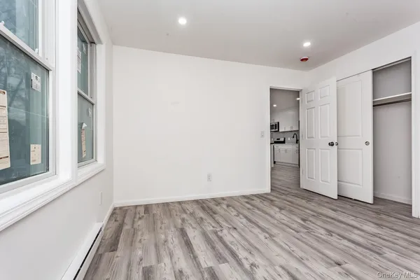 a view of empty room with wooden floor and entryway