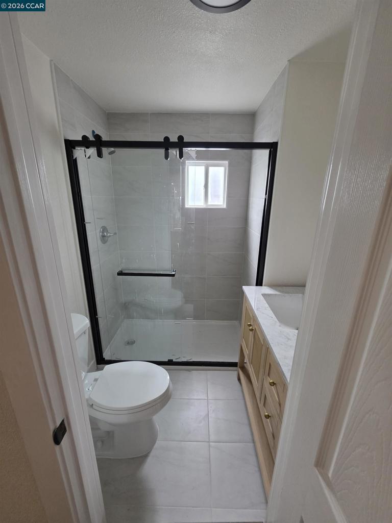 139 Ambrose Avenue Bay Point, CA 94565 - Photo 4 of 13 a bathroom with a sink a toilet a mirror and a shower