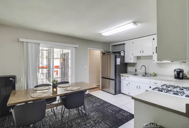 a kitchen with stainless steel appliances kitchen island granite countertop a sink dishwasher a stove and a refrigerator with wooden floor