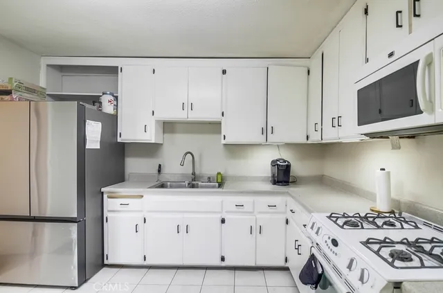 a kitchen with stainless steel appliances a stove a sink and a refrigerator