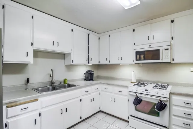 a kitchen with white cabinets and white appliances
