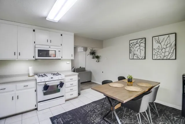 a kitchen with a stove a sink cabinets and a dining table