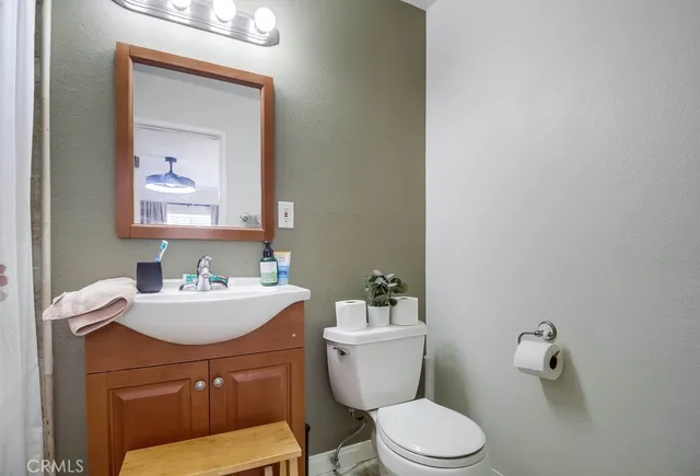 a bathroom with a toilet a sink and mirror