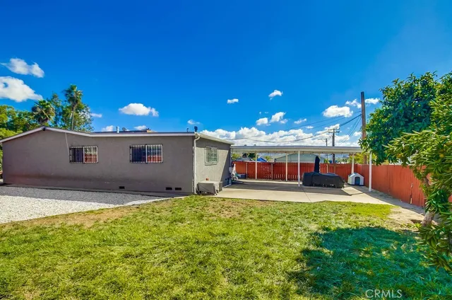 a view of a house with a yard and potted plants