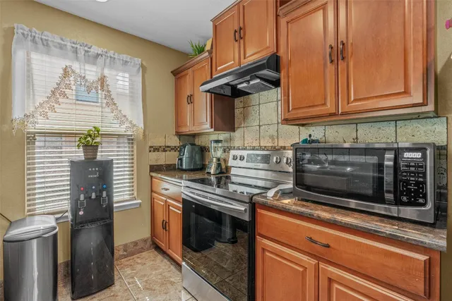 a kitchen with stainless steel appliances granite countertop a stove a microwave and cabinets