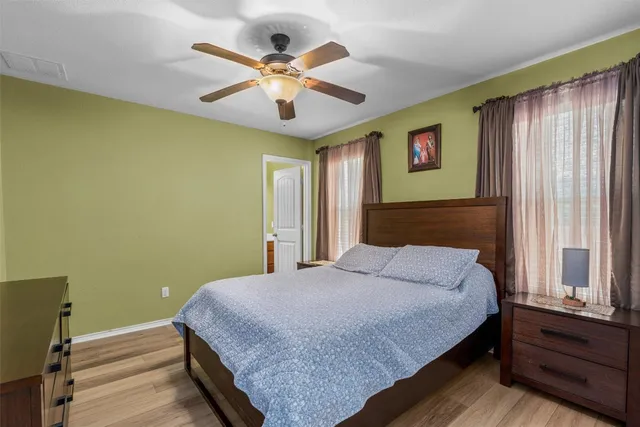 a bedroom with a large bed chandelier and a window