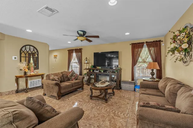 a living room with furniture a large window and a flat screen tv
