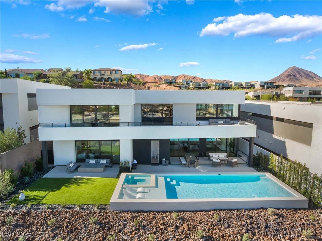 Rear view of property featuring an outdoor living space, stucco siding, a mountain view, and a patio