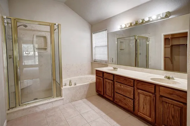 a spacious bathroom with a tub sink shower and mirror