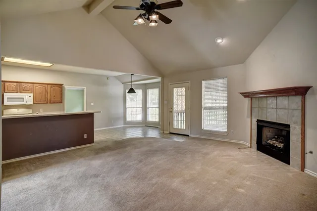 a view of an empty room with a fireplace and a window
