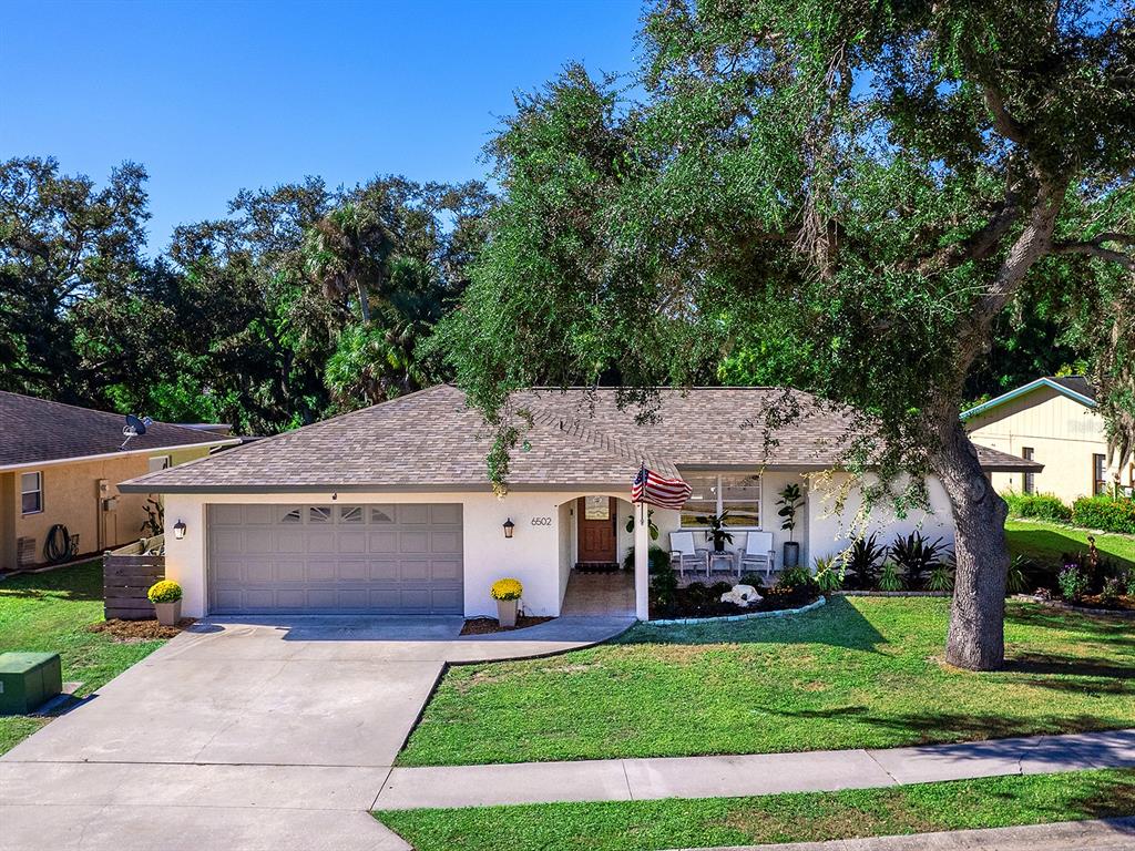 6502 Bikini Way Sarasota, FL 34241 - Photo 1 of 43 a aerial view of a white house in front of a big yard with large trees
