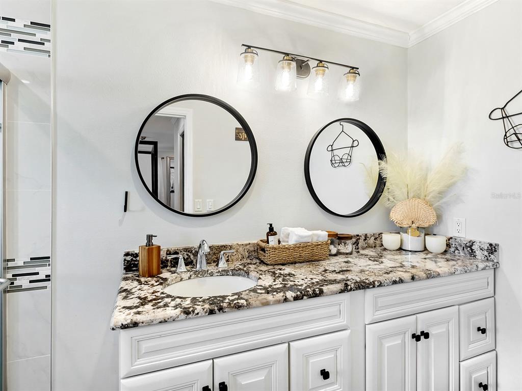 6502 Bikini Way Sarasota, FL 34241 - Photo 27 of 43 a bathroom with a granite countertop double vanity sink and a mirror