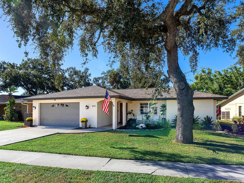 6502 Bikini Way Sarasota, FL 34241 - Photo 43 of 43 a view of a white house with a yard and large trees