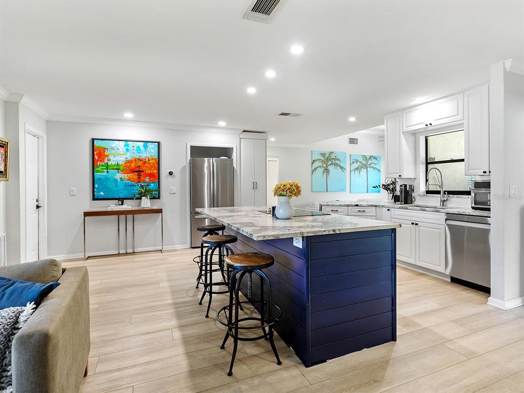 6502 Bikini Way Sarasota, FL 34241 - Photo 5 of 43 a living room with kitchen island furniture and a flat screen tv