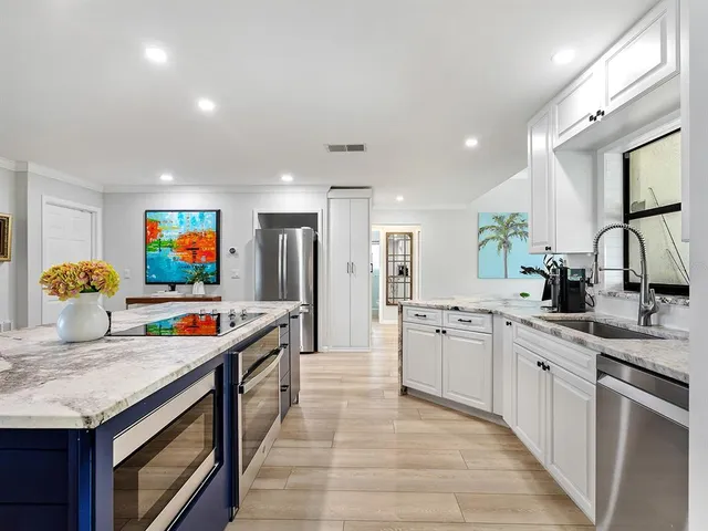 a kitchen with stainless steel appliances granite countertop a sink and stove top oven