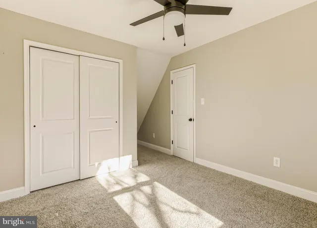 a view of an empty room with a ceiling fan