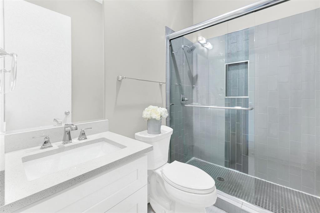 4060 Spring Valley Road, Unit 105 Farmers Branch, TX 75244 - Photo 16 of 19 a bathroom with a sink a toilet and shower