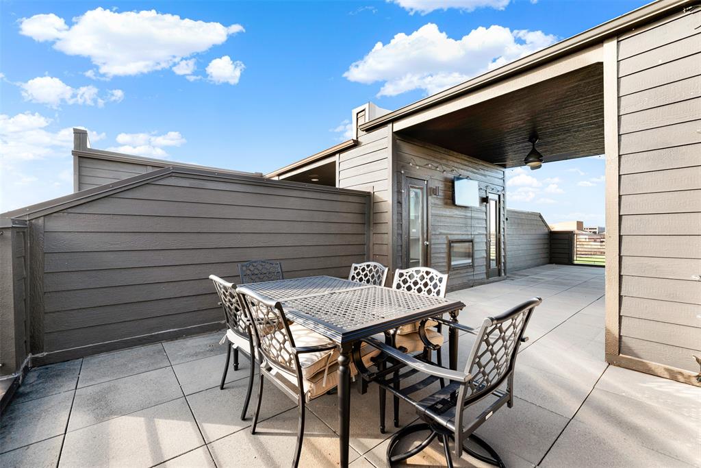 4060 Spring Valley Road, Unit 105 Farmers Branch, TX 75244 - Photo 18 of 19 a view of a patio with table and chairs with wooden floor and fence