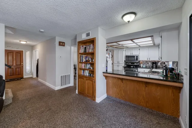 a kitchen with stainless steel appliances granite countertop a refrigerator and a sink