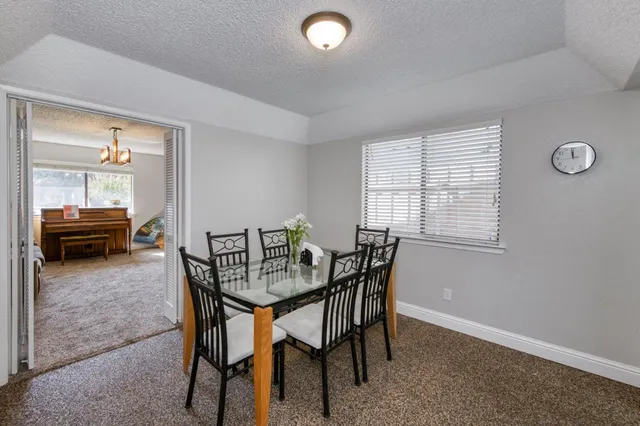 a view of a dining room with furniture and a window