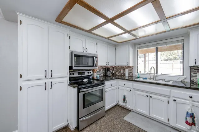 a kitchen with appliances a sink and cabinets