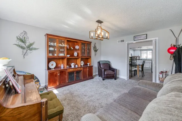 a living room with furniture a dining table and a chandelier