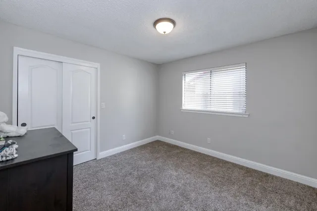 an empty room with a window and a bathroom