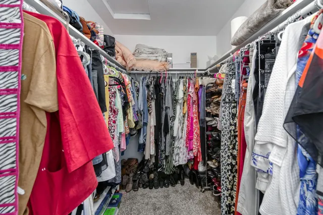 a view of walk in closet with clothes