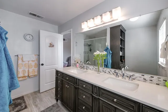 a bathroom with a double vanity sink and a mirror