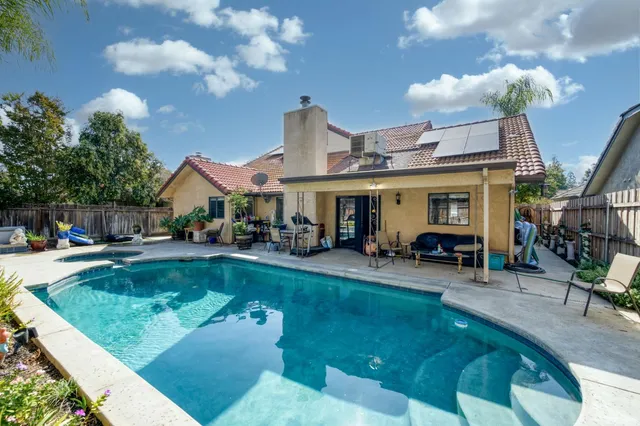 a view of a house with swimming pool and sitting area