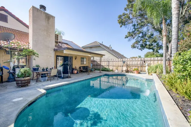 a view of a house with swimming pool and sitting area