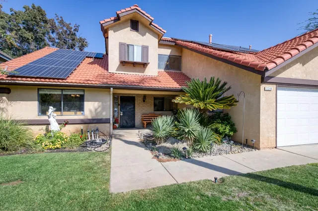 a front view of a house with a garden and plants