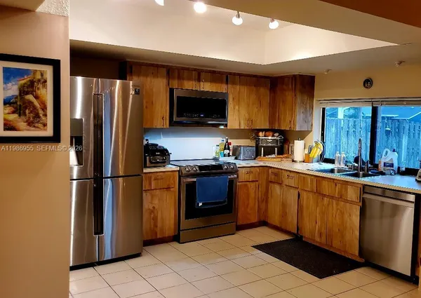 a kitchen with stainless steel appliances granite countertop a refrigerator sink and microwave