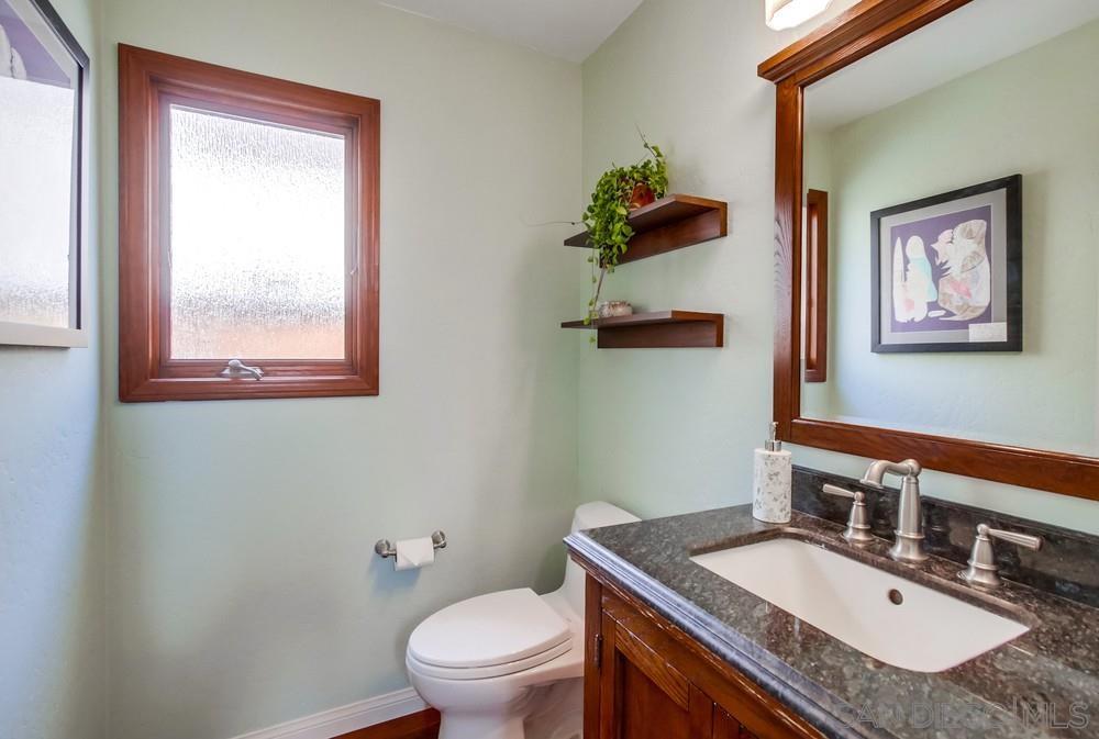 12128 Eagle Street San Diego, CA 92131 - Photo 18 of 37 a bathroom with a granite countertop toilet a sink and mirror
