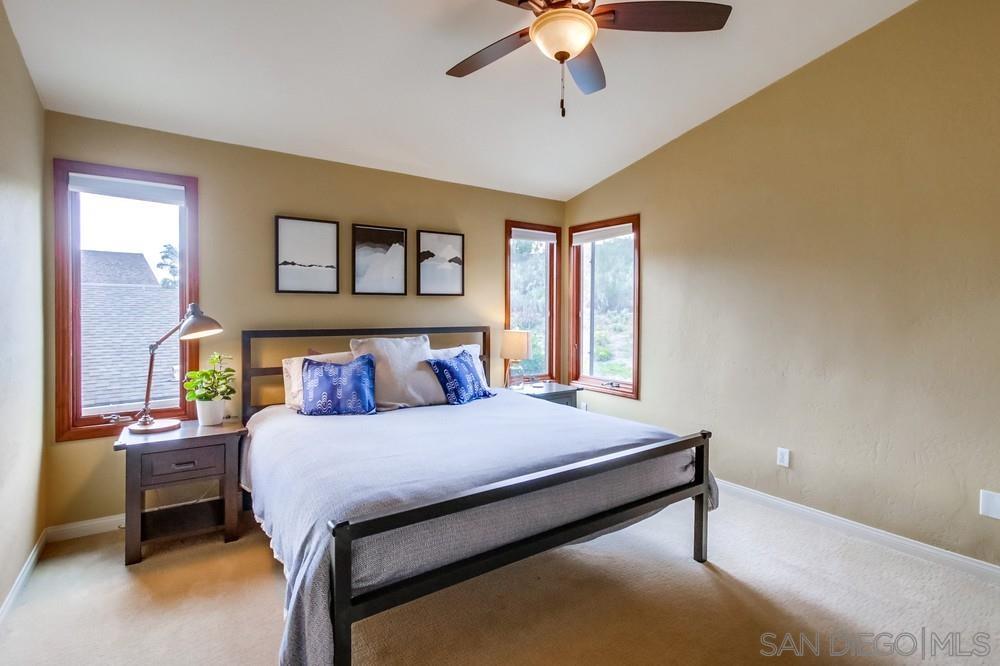 12128 Eagle Street San Diego, CA 92131 - Photo 21 of 37 a bedroom with a bed and a chandelier